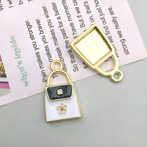 Detailed macro view showing the front and back of alloy bag charms with floral accents