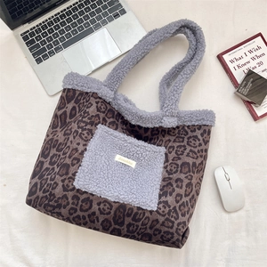 Detailed close-up of leopard print tote bag with grey plush pocket and fleece trim details