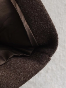 Close-up of wool blend fabric and smooth satin lining on a dark brown coat