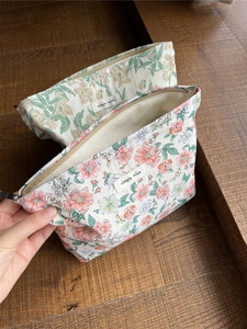Detailansicht von Baumwoll-Kosmetiktaschen mit Blumenmuster, Reißverschluss und Stoffetikett
