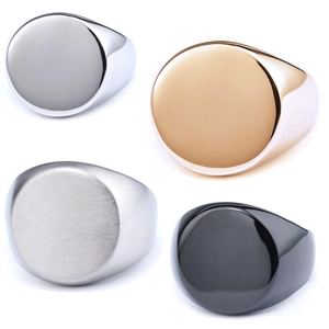 Close-up of round stainless steel signet rings in gold, silver, and black metal finishes