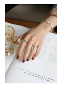 Detail of vintage silver S925 ring with portrait coin and bold chain design
