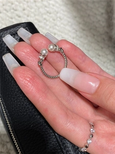 Detailed view of silver twisted cable ring featuring two white pearls and micro-zirconia