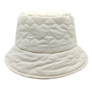 Detail of heart-shaped quilted pattern on white padded bucket hat with subtle glossy finish