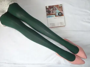 Détail de collants vert foncé pour femmes portés avec des chaussures plates roses