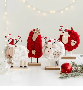 Detailed view of red and white wool felt Xmas ornaments on wooden bases with festive lights
