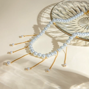 Macro detail of elegant 18k gold stainless steel necklace with cascading white pearls