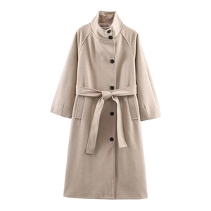 Detailed view of oatmeal-colored wool coat featuring a belted waist and dark buttons