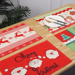 Detail view of festive Christmas placemats with Santa and reindeer on wooden table