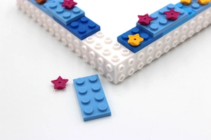 Detail of DIY building block photo frame with colorful star pieces and blue bricks