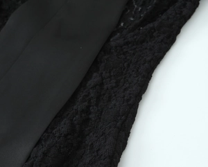 Macro shot of black lace and satin fabric texture on a two-piece bodysuit and mini skirt set