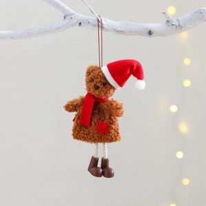 Christmas teddy bear ornament with red hat and scarf hanging on a festive snowy branch