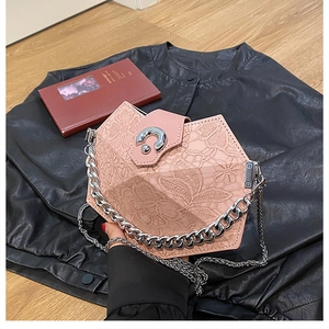 Detail of pink lace rhombic shoulder bag with silver metal buckle and chain on leather