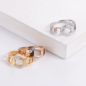 Macro detail of hollow chain link rings in silver gold and rose gold with pavé zircon