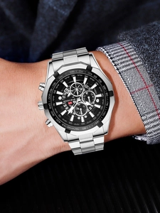 Close-up of silver steel men's watch with black chronograph dial worn on wrist
