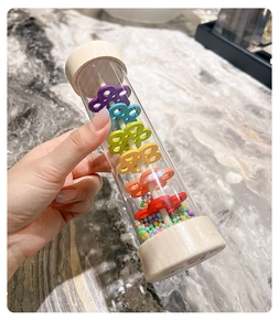 Macro shot of wooden rainmaker toy with colorful beads and flower-shaped dividers