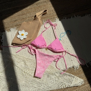 Hot pink halter bikini set with white daisy floral print high waist bottom on beach rug