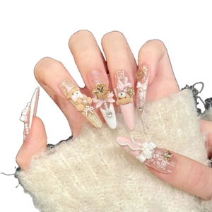 Pink and white press-on nails with 3D teddy bears, bows, and snowflake decorations