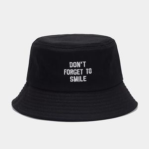 Detail of white letter embroidery on a black cotton bucket hat with premium stitching