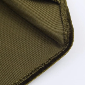 Gros plan détaillé du tissu en velours côtelé vert olive avec coutures de bordure