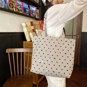 Sac fourre-tout en toile à pois avec broderie nœud porté dans un décor élégant