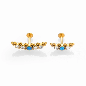 Macro view of gold stainless steel labret studs with blue opal and white zircon stones