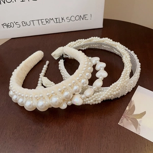 Three assorted pearl headbands featuring large twisted and heart-shaped faux pearl designs