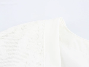 Detail eines weißen französischen Jacquard-Kleids mit Spitzenmustern und feiner Textur