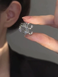 Detailed macro shot of silver flower ear cuff with sparkling zircon stone inlay