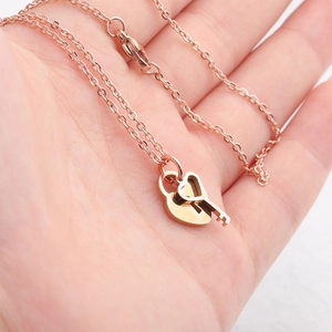 Rose gold stainless steel heart lock and key pendant necklace on a delicate O-chain