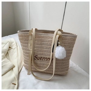 Detail of beige straw tote bag with Suemm print, white pom-pom charm and PU straps