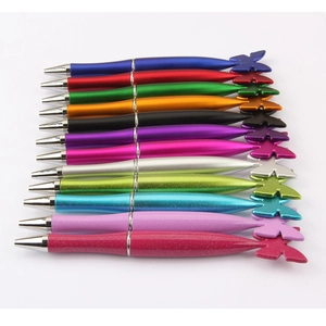 Detailed view of colorful butterfly shaped ballpoint pens with metallic glitter finish