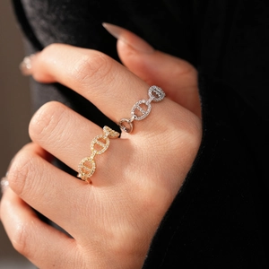 Macro shot of gold and silver chain link rings featuring sparkling cubic zirconia stones
