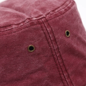 Detail of burgundy washed cotton hat with brass eyelets and double-row stitching
