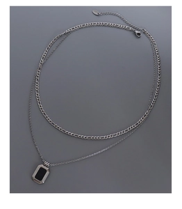 Detail of double-layer silver stainless steel necklace with black rectangular pendant