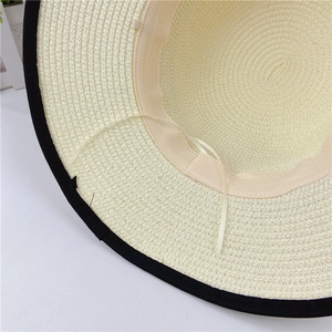 Detail of woven straw sun hat showing interior sweatband and adjustable ribbon strap