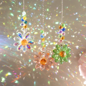 Close-up of crystal flower suncatchers casting rainbow light spots on a wall
