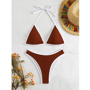 Flachliegendes Detail von karamellfarbenem Struktur-Bikini mit weißen Kontrastkanten