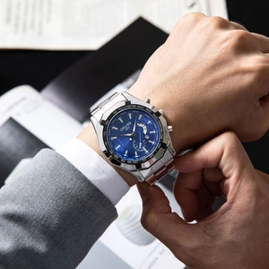 Close-up of luxury chronograph watch with blue dial on a man in a business suit