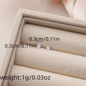 Macro shot of silver zircon stud earrings measuring 0.3cm in a jewelry gift box