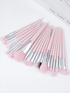 Flat lay of a 20-piece pink makeup brush set with silver ferrule on a white background