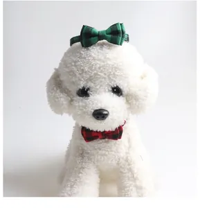 Close-up of red and green plaid bow tie pet collars on a white puppy model