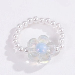 Close-up of white beaded ring featuring an iridescent glass flower charm for women