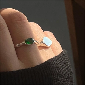 Close-up of minimalist 925 silver rings with green oval gemstone on a model hand