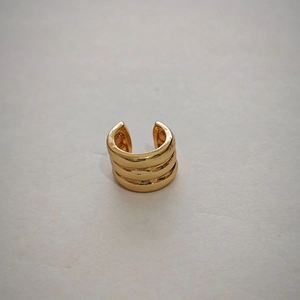 Close-up of triple-layered gold ear cuff with polished finish for non-pierced ears