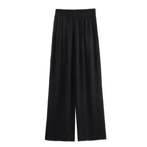 Detailed view of black wide-leg trousers with elastic high waist and silky drape fabric