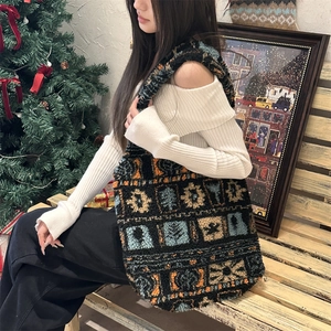 Ethnic plush tote bag with geometric floral patterns worn by a model in a cozy winter setting