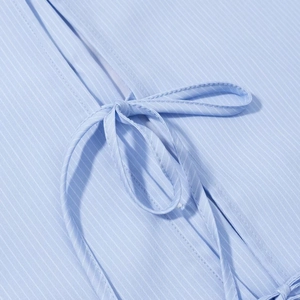 Close-up of blue fine striped fabric texture with elegant front tie-knot detail on shirt