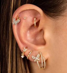Close-up of gold butterfly S925 silver earrings with zircon inlays on a model