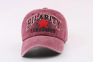 Detailed embroidery of HILARITY text and star on washed red vintage cotton baseball cap